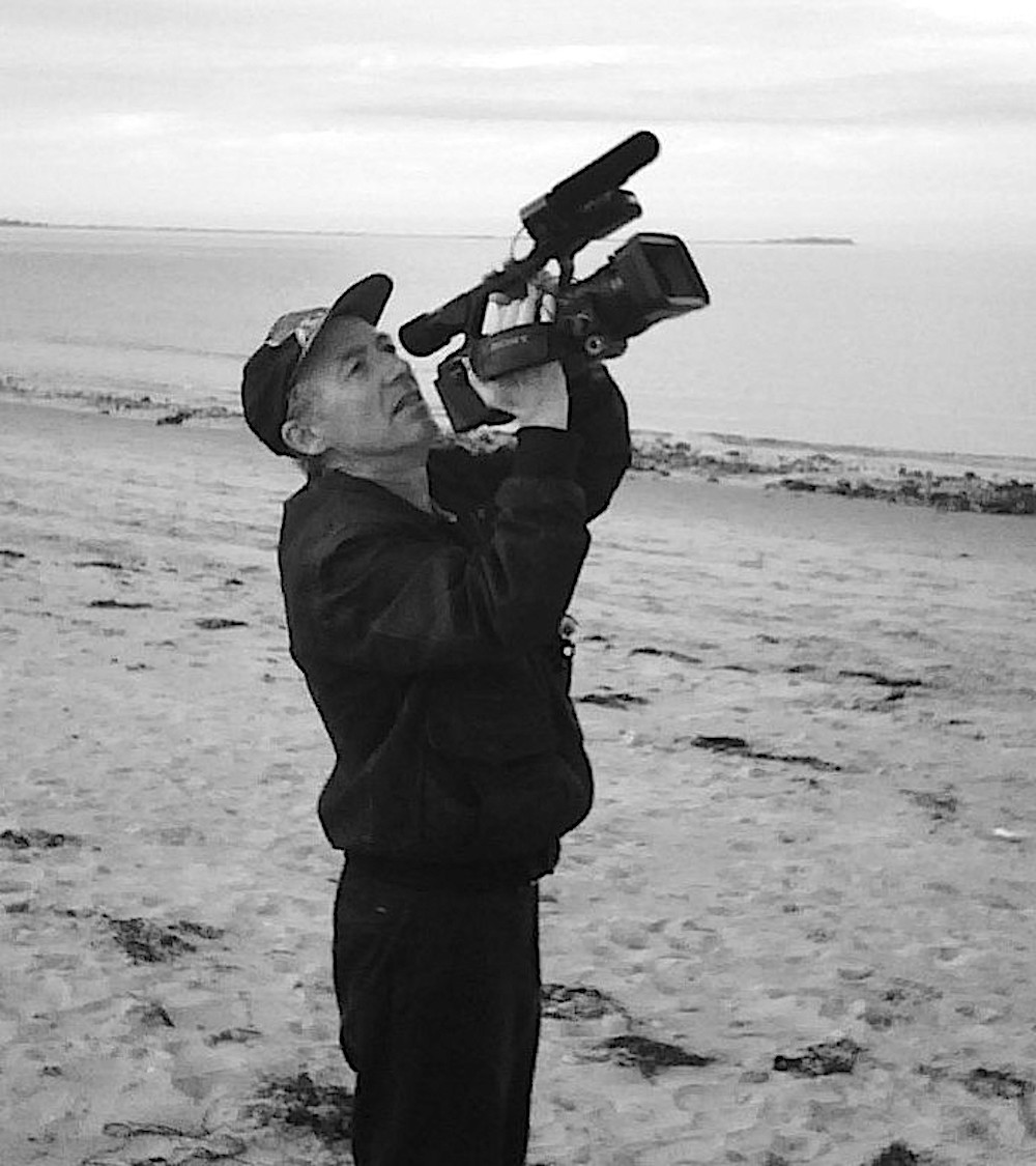 Richard Dindo, 2008 - Foto: Bruce A. Mackenzie - Lizenz: https://creativecommons.org/licenses/by-sa/4.0/deed.en - Datei: https://commons.wikimedia.org/wiki/File:Richard_Dindo_at_Plymouth_beach.jpg