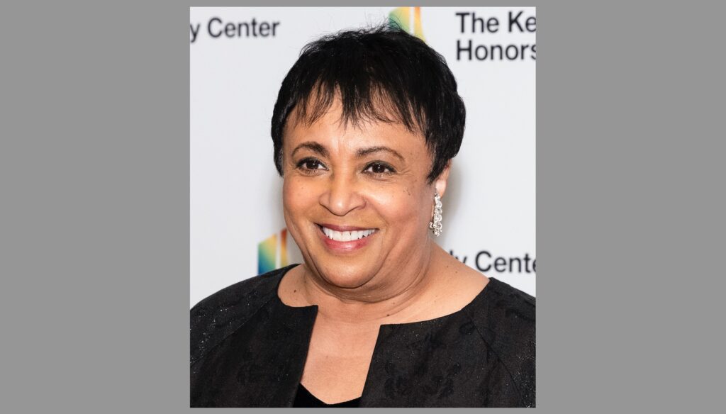 Bild: Carla Hayden, 2021 - Foto: Library of Congress Life, https://www.flickr.com/people/162991176@N03 - Lizenz: https://creativecommons.org/publicdomain/zero/1.0/deed.en - Datei: https://commons.wikimedia.org/wiki/File:Carla_Hayden_2021_Kennedy_Center_Honors_(cropped).jpg