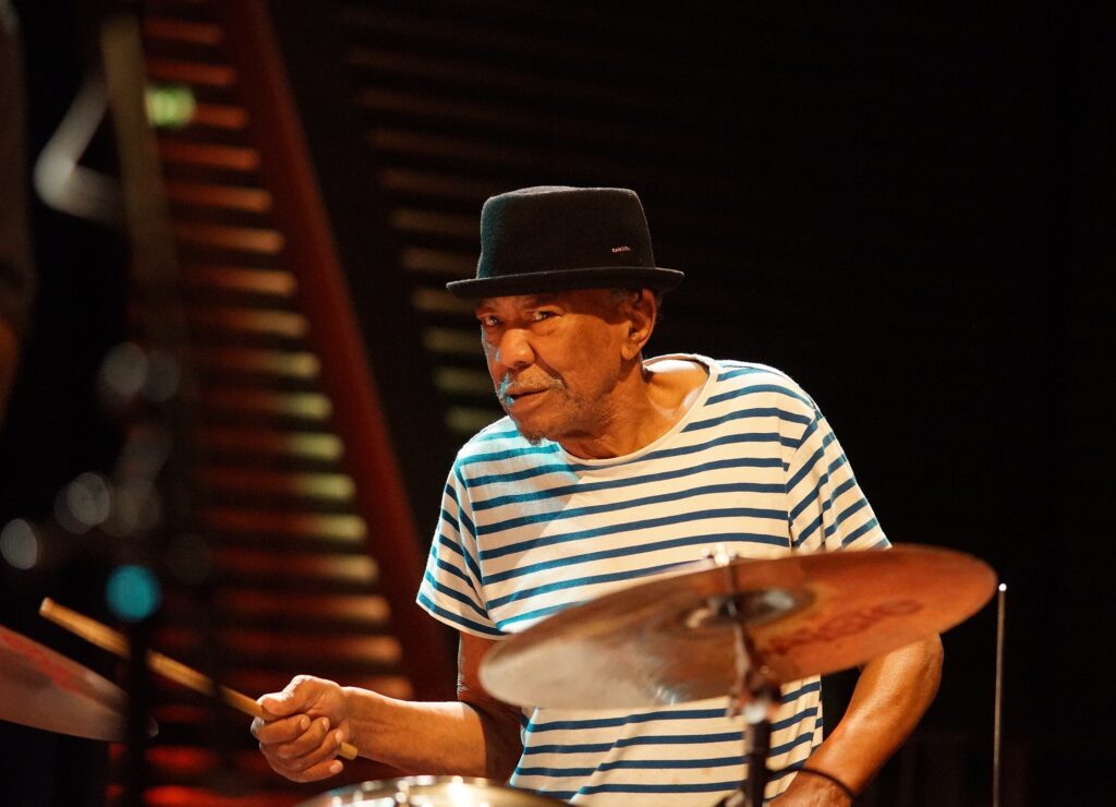 Louis Moholo, 2019 - Foto: Dirk Neven, https://www.flickr.com/people/146907430@N03 - Public domain - Datei: https://commons.wikimedia.org/wiki/File:Louis_Moholo-Moholo_%275_Blokes%27,_BIM_5_september_2019_-_Louis_Moholo_DSC03477_(48687185046).jpg