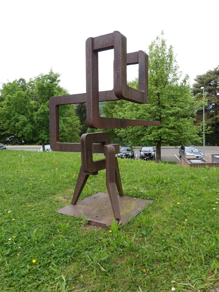 Bild: Werk vom James Licini, Cortenstahl, Höhe 114 cm, Gemeindeverwaltung Urdorf - Foto: Dnalor11 - Lizenz: https://creativecommons.org/licenses/by-sa/4.0/deed.en - Datei: https://commons.wikimedia.org/wiki/File:James_Licini_Urdorf.jpg