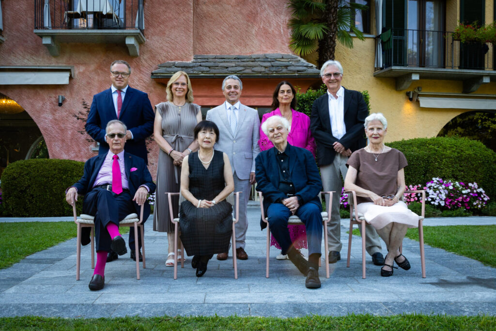 v.l.n.r.: Gastgeber Frank A. Meyer, Atzuko Muschg, Preisträger Adolf Muschg, Gastgeberin Lilith Frey. stehend v.l.n.r.: Mario Voigt, Ministerpräsident von Thüringen, Andrea Lindholz, Vizepräsidentin des Deutschen Bundestages, Ignazio Cassis, Schweizer Bundesrat, Maja Hoffmann, Präsidentin Locarno Film Festival, Andreas Isenschmid, Publizist und Literaturkritiker.