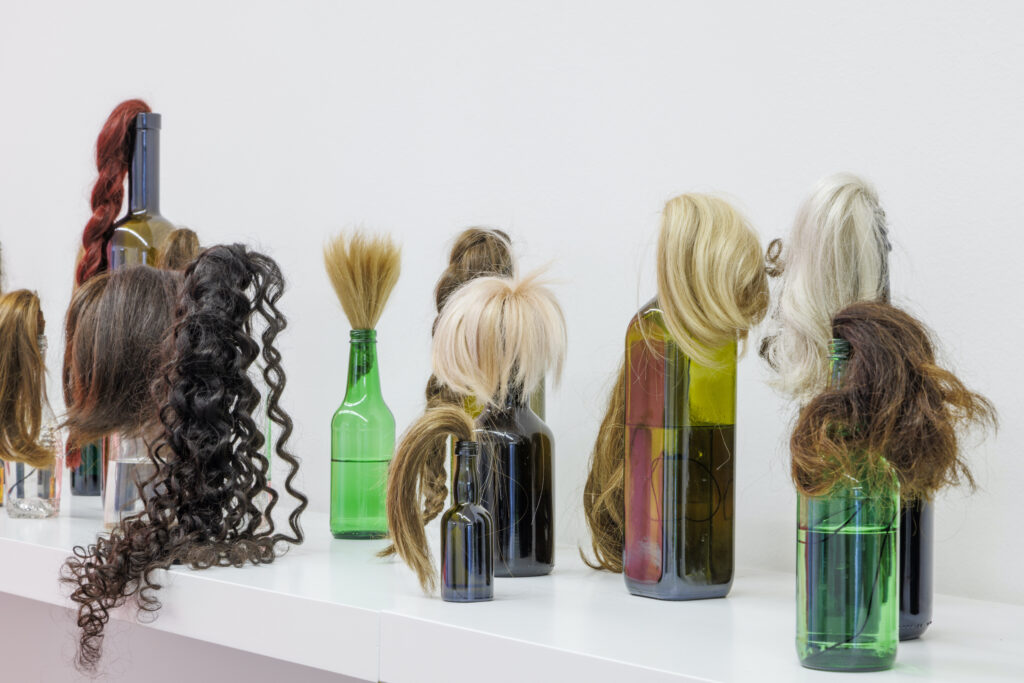 Isabelle Krieg, "Hair Cocktails", 2023, Frauenhaar, Flaschen, Schnur, Brennsprit, destilliertes Wasser, Grösse variabel © F.X. Brun
