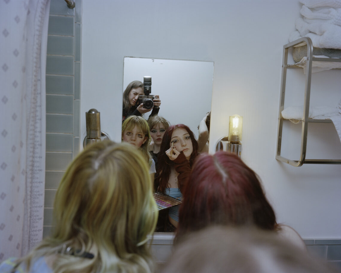 Sara Messinger, Self-portrait of me photographing Avril and friends doing makeup at Avril's seventeenth birthday party. This image is part of my on-going work documenting a group of Gen-Z youth growing up in New York Cit