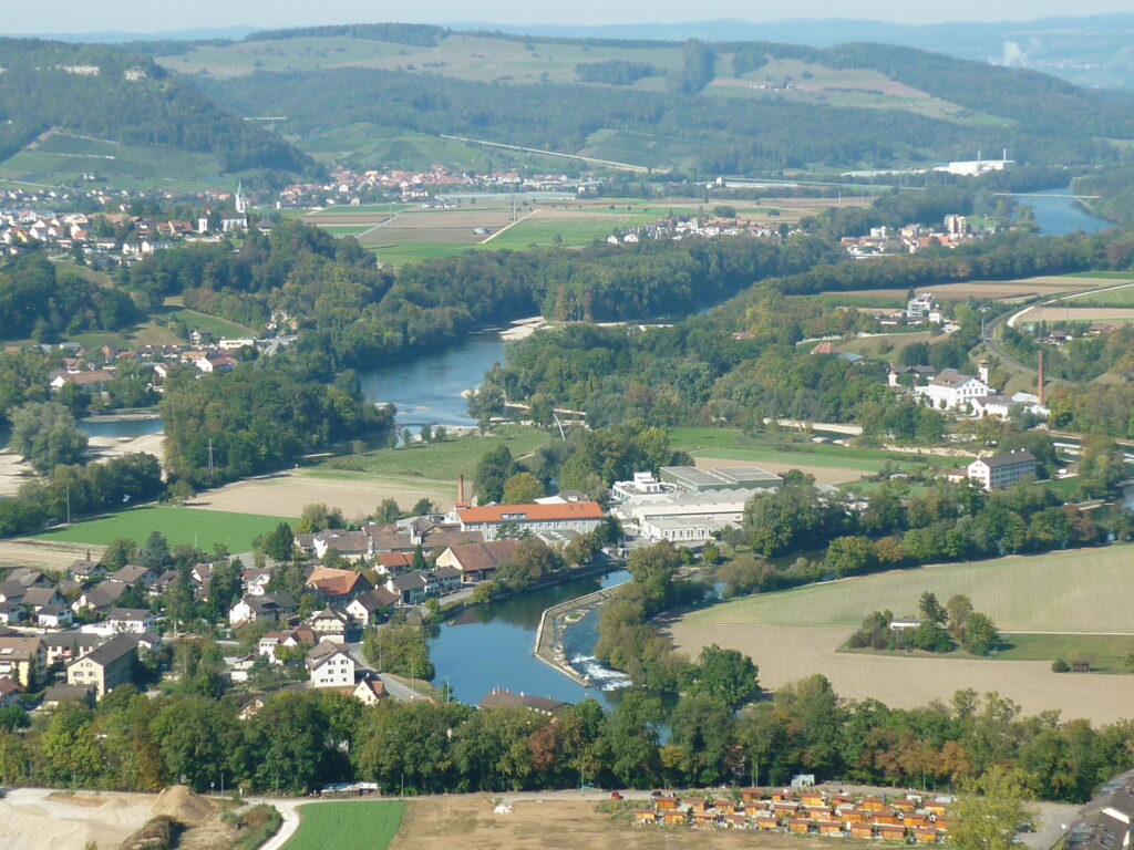 Zusammenfliessen von Aare, Limit und Reuss - Blick auf den Gebenstorfer Ortsteil Vogelsang und das "Wasserschloss", in der Mitte unten die Limmat, von links nach rechts die Aare, 2009 - Foto: https://commons.wikimedia.org/wiki/User:Paebi (gem. Wikimedia vermutet) - Lizenz: https://creativecommons.org/licenses/by-sa/3.0/deed.en - Datei: https://commons.wikimedia.org/wiki/File:Gebenstorf02.JPG