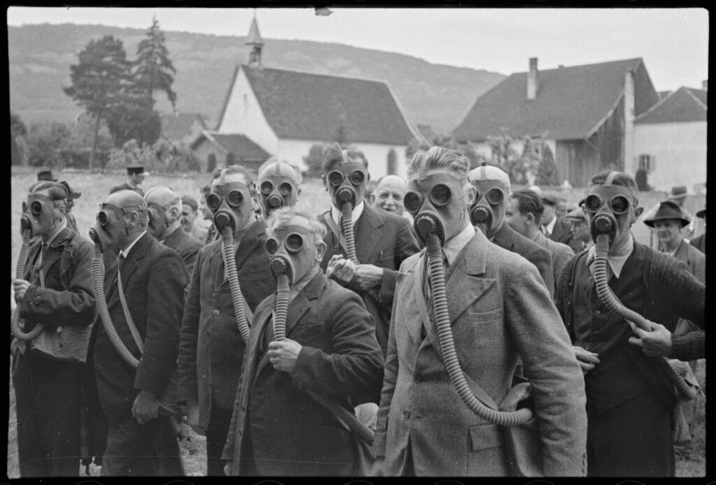 Le maniement du masque à gaz sur la place de l’étang à Delémont avant l'éclatement de la Seconde Guerre mondiale, par Enard frères. (Photo / Musée jurassien d’art et d’histoire, Delémont.)
