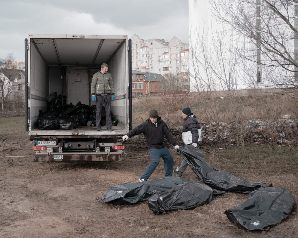 Krieg in der Ukraine - Männer laden die Toten aus dem Massengrab, in einen Kühllaster, 2022, Butscha, Ukraine, Europa