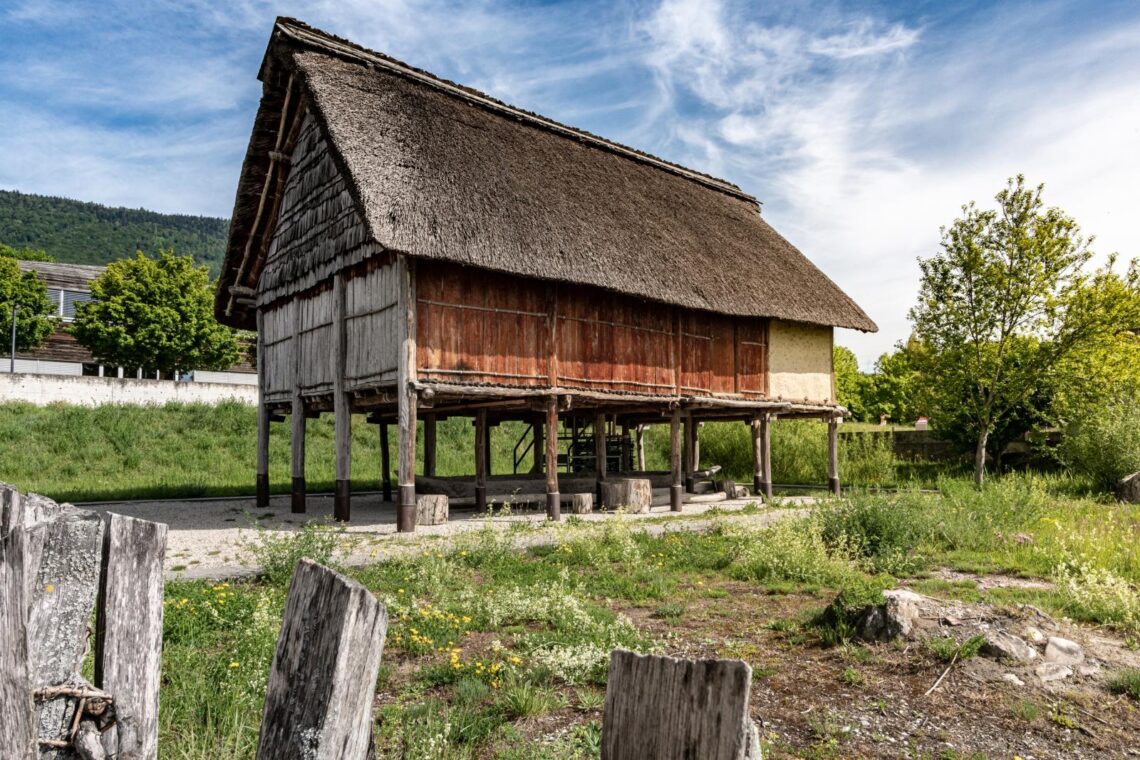 Rekonstruiertes Pfahlbauhaus im Laténium am Neuenburgersee. © Quentin Bacchus, https://ourheritage.ch/article/welterbetage