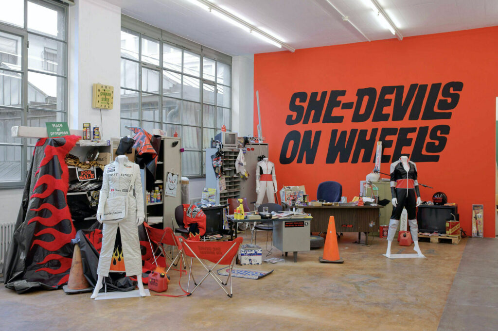 Sylvie Fleury, She-Devils on Wheels - Headquarters (1997), Sammlung Migros Museum für Gegenwartskunst, Exhibition view MAMCO Geneva, 2008. Photo: Ilmarie Kalkkinen, © Sylvie Fleury.