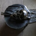 Die «Markttische» im Kreuzgang des Basler Müsters, sind eine Arbeit von Bettina Eichin. Totenkopf auf einer Basler Trommel, die neben dem einen Tisch steht . - Foto: Bobo11, https://commons.wikimedia.org/wiki/User:Bobo11 - Lizenz: https://creativecommons.org/licenses/by-sa/4.0/deed.en - Datei: https://commons.wikimedia.org/wiki/File:Basel_M%C3%BCnster_Kreuzgang_Marktische_P6A9209.jpg