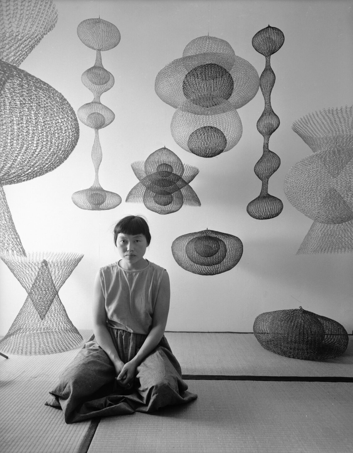 Ruth Asawa inmitten mehrerer ihrer aus Drahtschlingen gefertigten Skulpturen, November 1954. Foto: Nat Farbman/The LIFE Picture Collection/Shutterstock Artwork © 2026 Ruth Asawa Lanier, Inc., Courtesy David Zwirne
